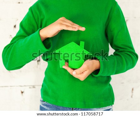 Little girl holding green house in hands. Concept