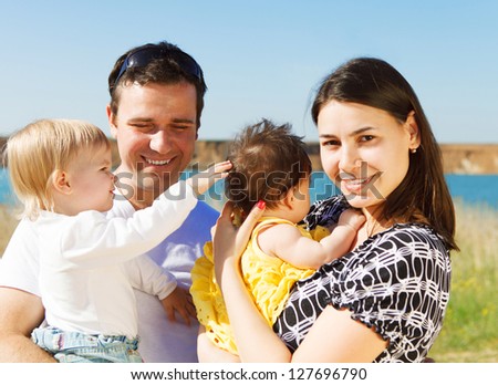 Happy young family with two children near the lake outdoors