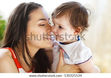 Happy smiling mother with eight month old baby girl indoor