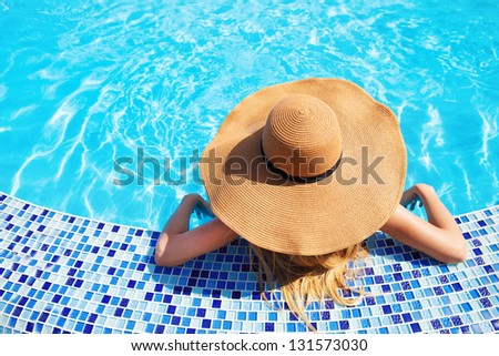 Pretty woman in a hat enjoying a swimming pool Pretty woman in a hat enjoying a swimming pool