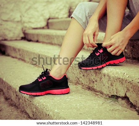 Athlete girl trying running shoes getting ready for jogging Athlete girl trying running shoes getting ready for jogging