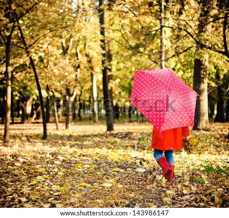 Little Girl With Polka Dots Umbrella Walking Through Alley With Fall Foliage