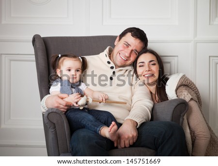 Happy Smiling Family With One Year Old Baby Girl Indoor