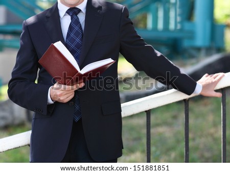 Close up of the hands of the businessman with a note book. Outdoors