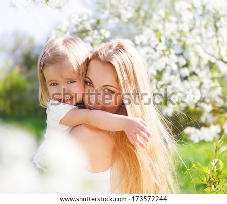 Happy mother and her little daughter in the spring day