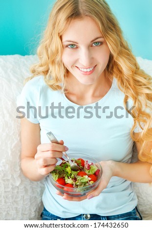 Woman diet concept portrait. Female model eating green salad
