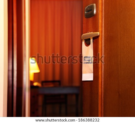 Please do not disturb sign hanging on open door in a hotel