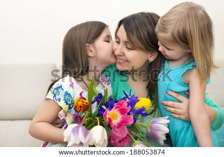 Happy woman and her little daughters in the living room Mother day concept Happy woman and her little daughters in the living room Mother day concept