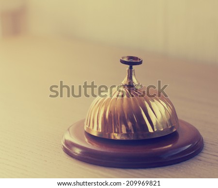 Old retro style hotel bell on a wood stand. Copy space