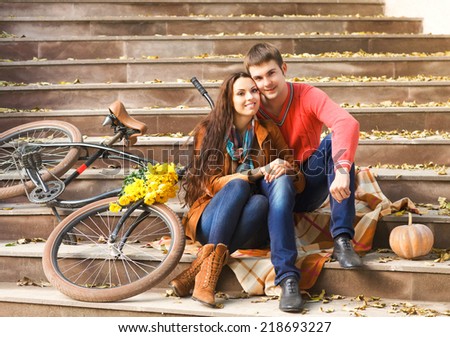 Happy young couple with bicycle in autumn park
