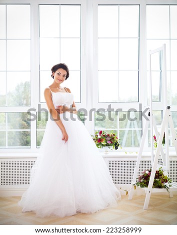 Young beautiful bride to be trying her dress in shop