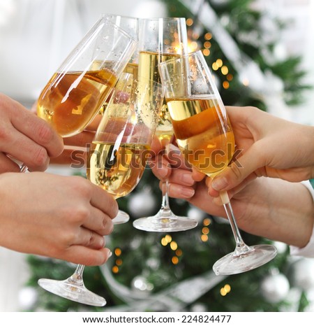 Christmas or New Year celebration. People holding glasses of champagne making a toast by the Christmas tree