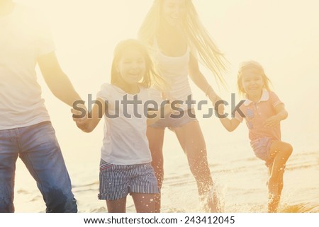 Happy young family having fun running on beach at sunset. Toned photo. Family traveling concept