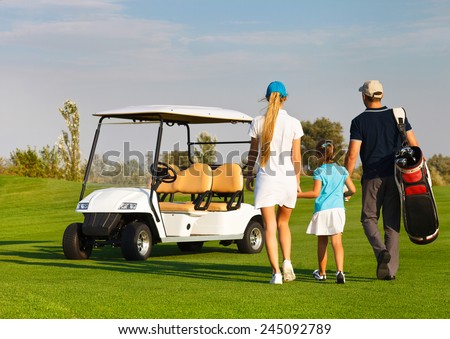 Young sportive family playing golf on a golf course