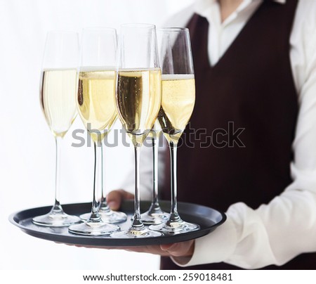 Professional male waiter in uniform serving champagne. DOF. Natural light. Photo in motion