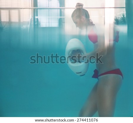 Young sporty woman underwater. Fitness concept. Very noisy. Underwater shot