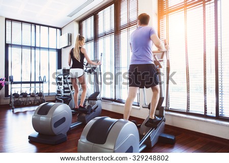 Healthy couple training on a treadmill in a sport center