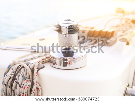 Sailboat detailed parts. Close up on winch and rope of yacht over blue sea. Yachting concept. Shallow depth of field