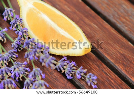 Lemon with lavender flowers on the wooden table. Close up