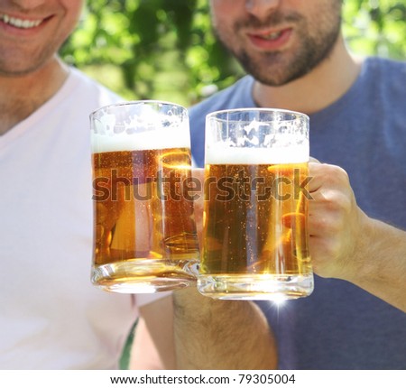 Two men with glasses of the light beer in the garden