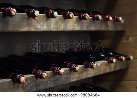 Bottles of red wine in rows in wine cellar