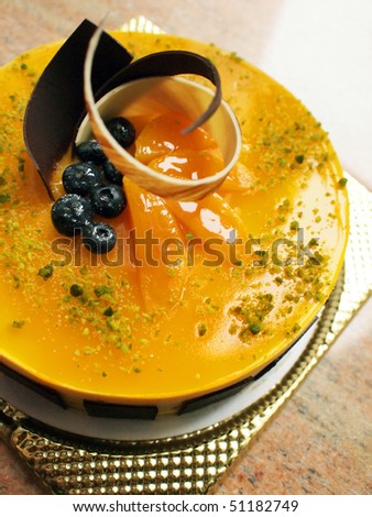 Mango mousse cake decorated with fruits and chocolate
