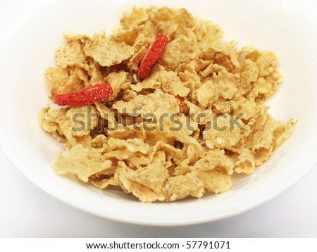 Corn flakes (cereal) with dried strawberry slices without milk in a bowl