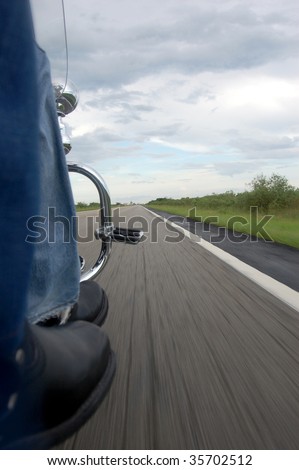 Motorcycle Riders moving on an open road from a low perspective