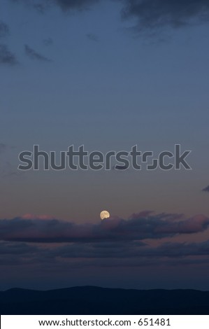 the moon low on the horizon during sunset