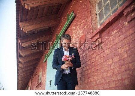 an image of Handsome man holding a bouquet of flowers