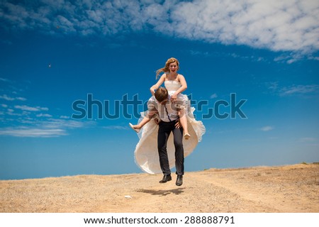 couple in love outdoors , the bride and groom walk and having fun at sea side