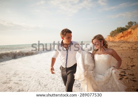 couple in love outdoors , the bride and groom walk and having fun at sea beach