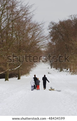Family walking with sled. Cold winter day.