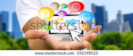 Young man holding computer in his hand surrounded by icons