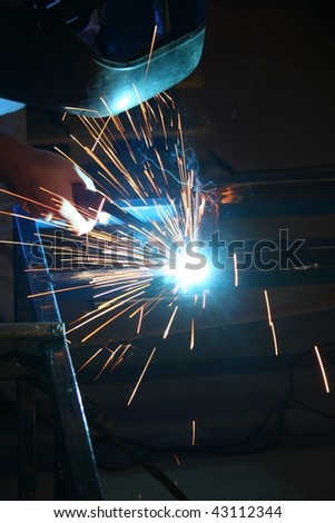 A picture of welder in the factory with dark background