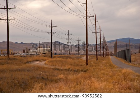 Major power lines are seen alongside a pedestrian walkway in a small city in the Rocky Mountains
