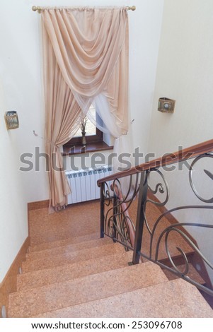 Interior wooden stairs with metal railing and floor lights