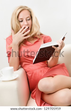 young woman in a red dress is reading a book