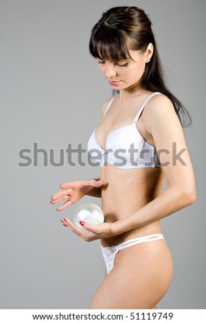 young woman in white linen with a silver sphere