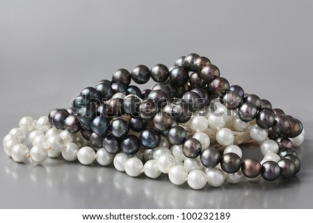 White and black pearls on silver background