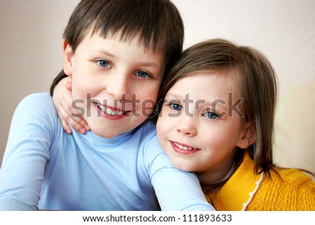 little boy and girl hugging over light background. sister and brother