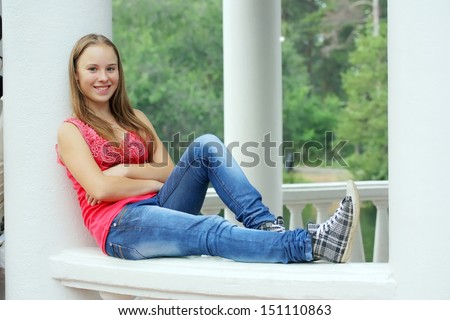A beautiful blond-haired 13-years old girl in the park, outdoor portrait