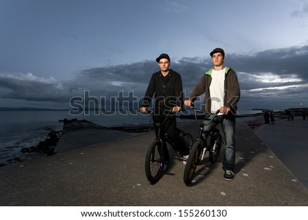 Two Young men with bicycles prepare to stunts at the street