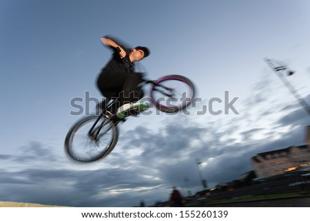 Young man performs stunts during sunset at the street. Blurred motion.