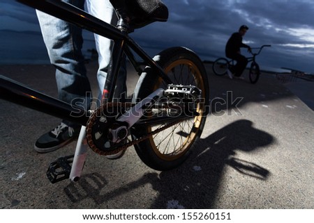 Young man with broken bicycle after stunts at the street. Detail