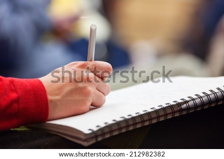 Close-up of Hands holding pens and making notes at the conference