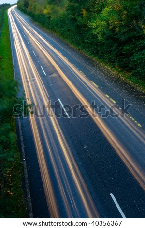 car lights trails on the busy highway in autumn dusk