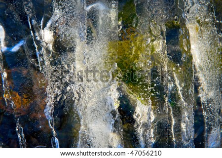 textured transparent sparkling piece of ice on stone background, abstract