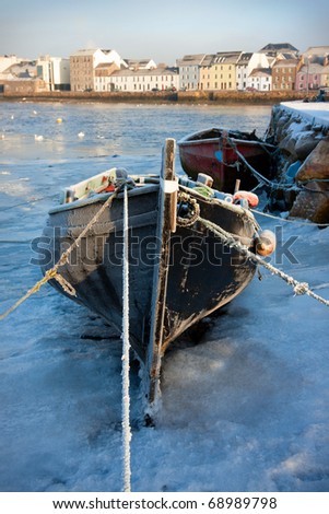boats covered by frost  and ice on Corrib river in Claddagh, Galway