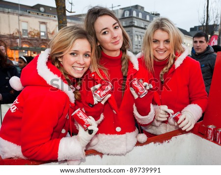 GALWAY - NOVEMBER 27: Coca-Cola crew stuff girls with festive treats at 'Holidays are coming' advert at Annual Galway Continental Christmas Market on November 27, 2011 in Galway, Ireland.